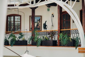 A balcony with potted plants, a wooden railing, and a view of the street. - Hotel Mama Cuchara by Art Hotels Ecuador (Quito)