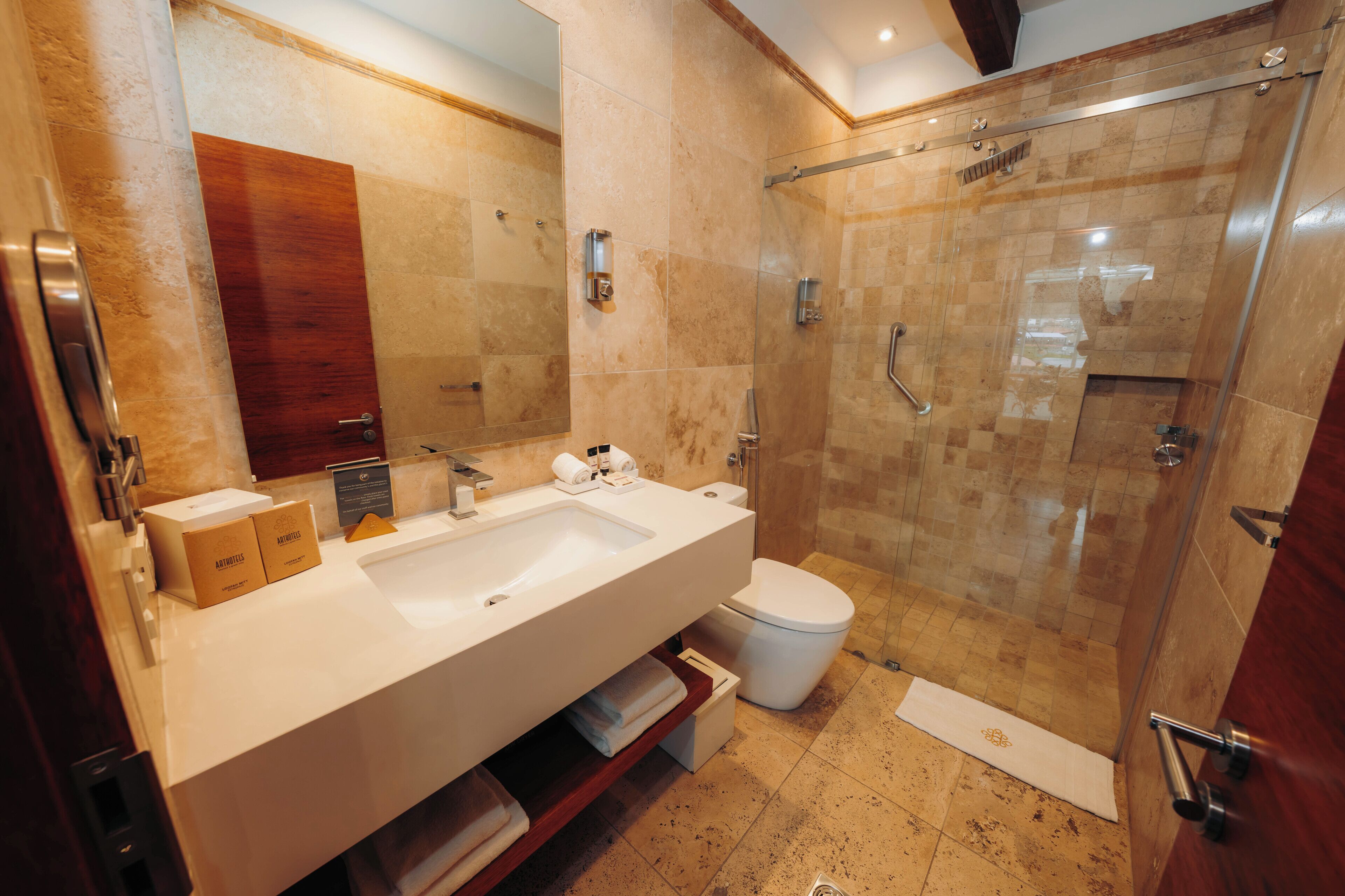 Un baño moderno con un lavamanos grande, espejo y ducha.
