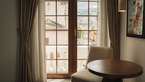 A room with a view through a glass door, a round table, and a chair. - Hotel Mama Cuchara by Art Hotels Ecuador (Quito)