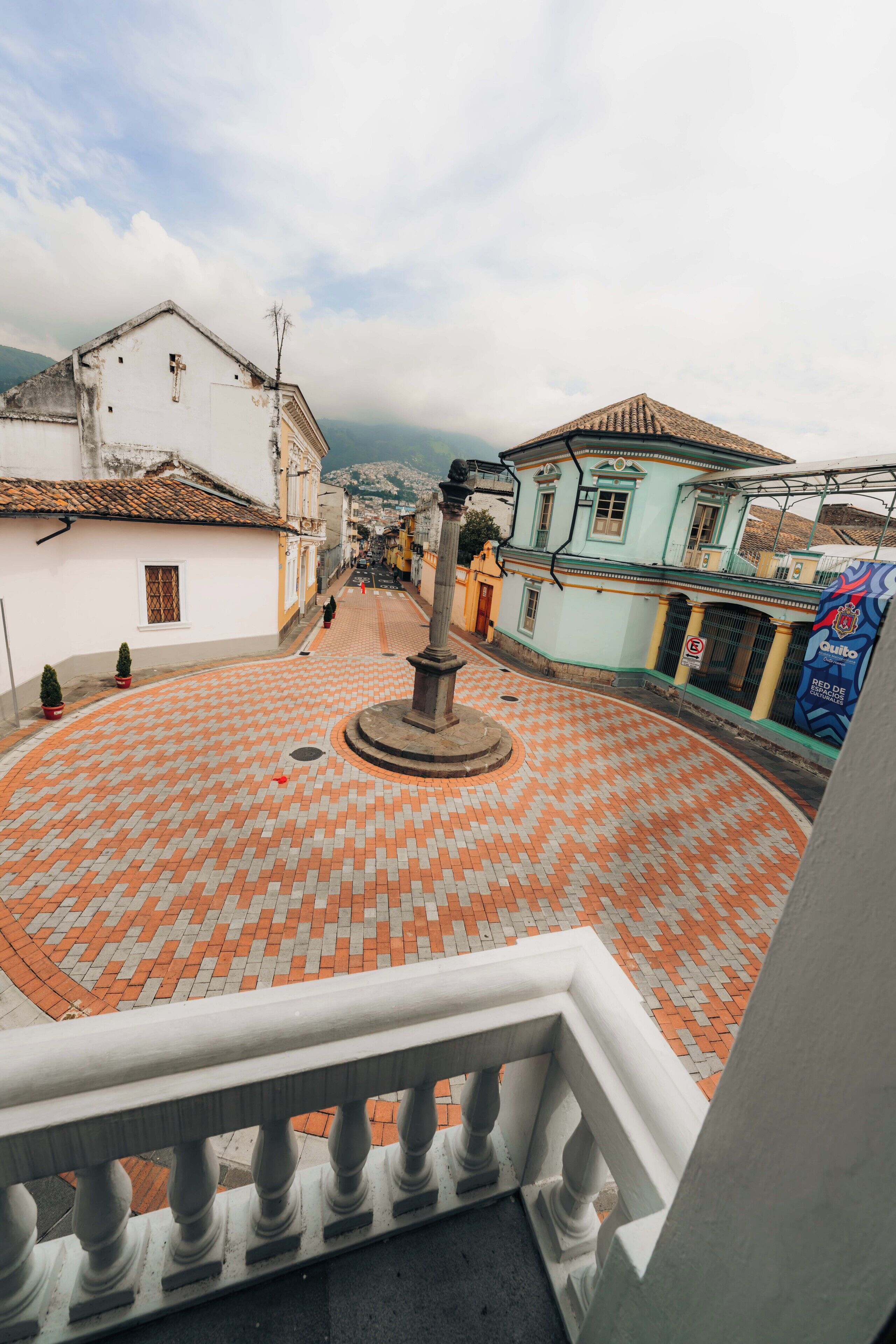 A circular plaza with a central monument, surrounded by buildings with traditional architecture.
