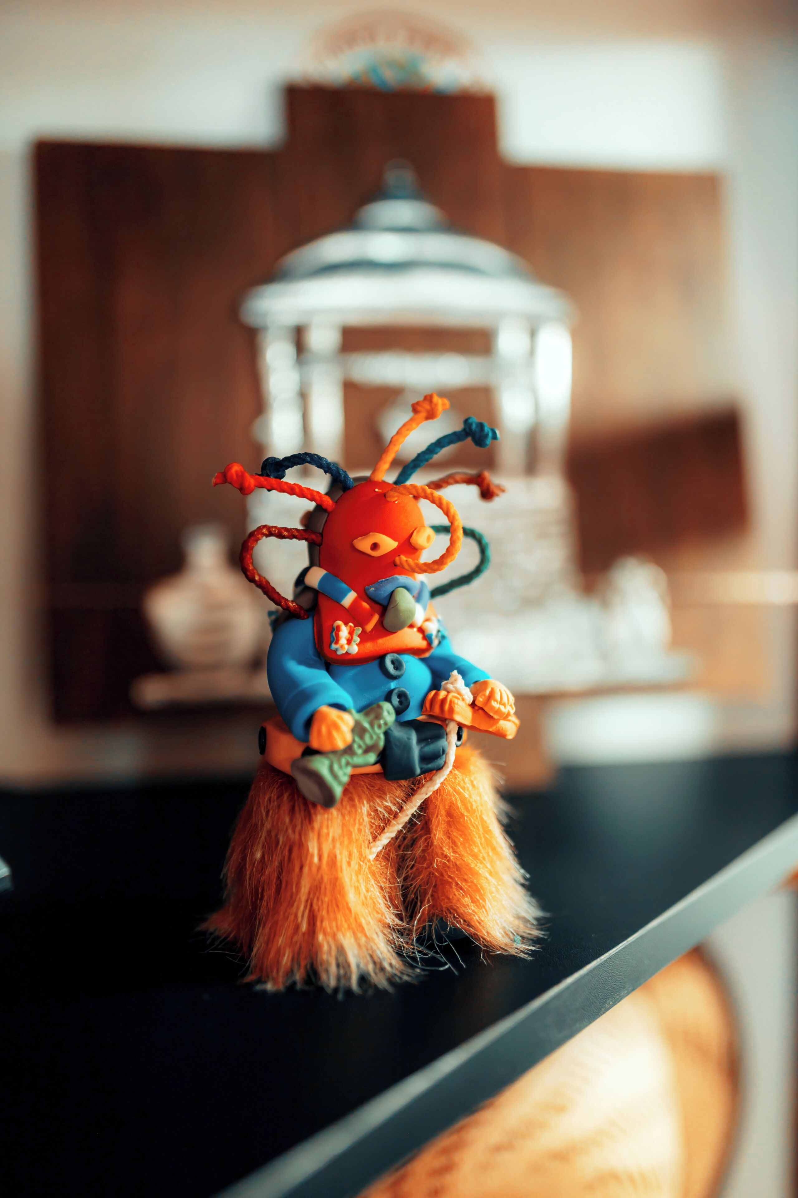 A plush toy on a shelf with a blurred background.