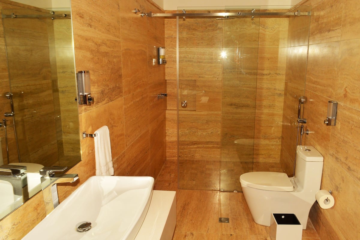 A bathroom with a bathtub, toilet, and a glass shower enclosure.