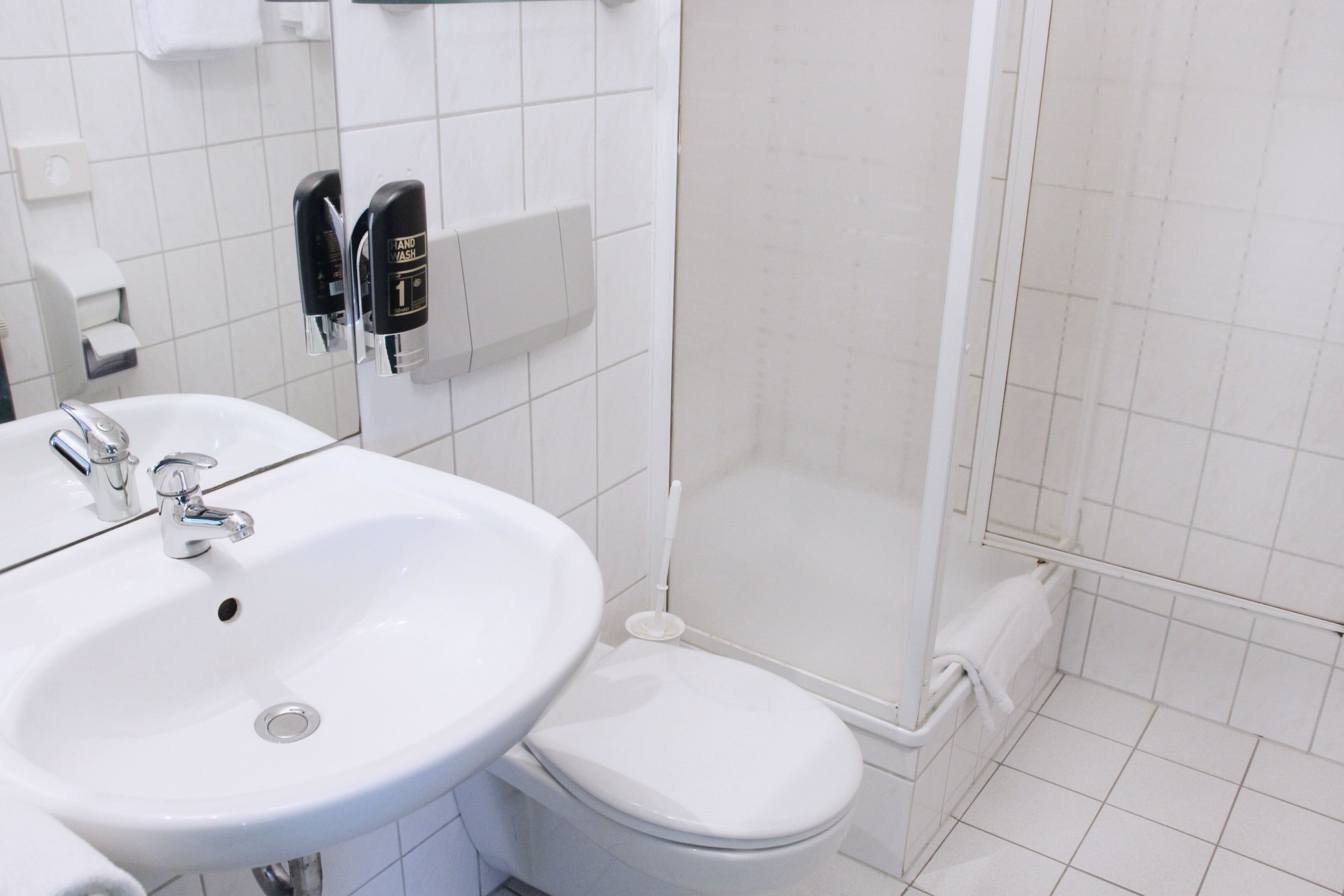 Un baño con lavabo blanco, inodoro y cabina de ducha de vidrio.