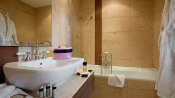 Un baño moderno con un lavamanos grande, una bañera y un box de ducha de vidrio.