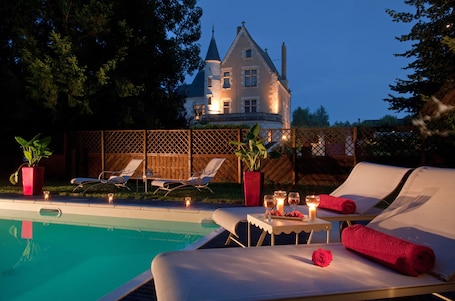Una piscina al aire libre, sillones reclinables de piscina