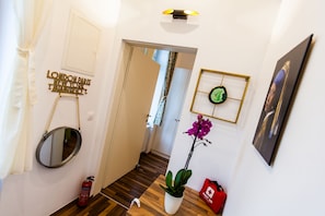 Stylish hallway with a mirror, potted orchid, and framed picture.