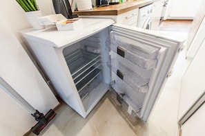 Modern kitchen with refrigerator, microwave, and ample storage.