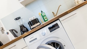 A modern kitchen with a built-in microwave, a coffee machine, a blender, and a Siemens washing machine. - Cosy 2 bedroom Apartment (Vienna)