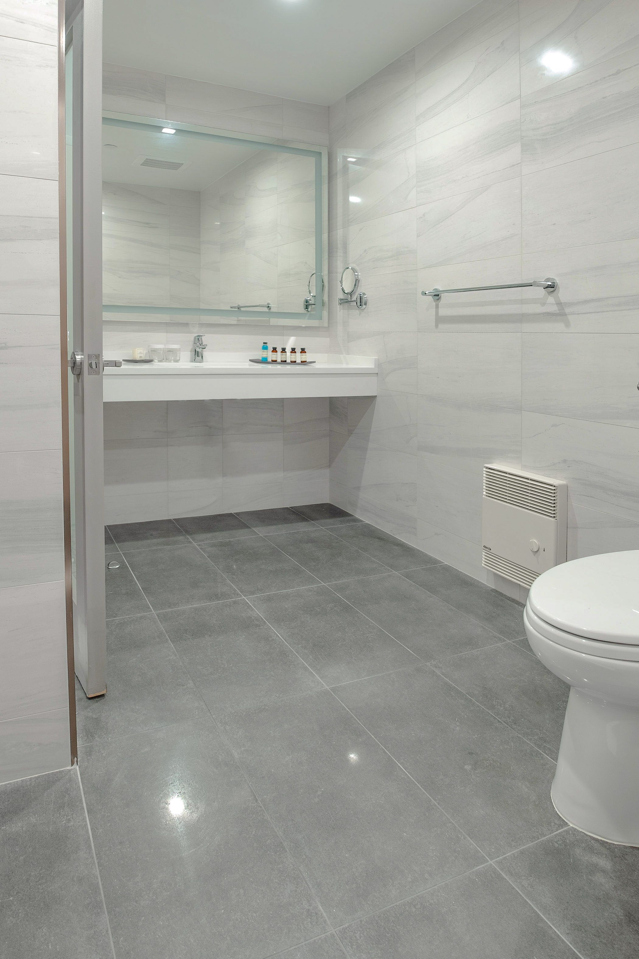A modern bathroom with a glass shower enclosure, a white sink, and a toilet.