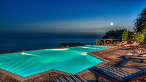 An infinity pool with a clear view of the ocean and a moon in the sky. - Etoile De Mer Villa (Andros)