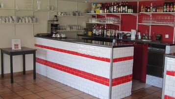 Uma cozinha com uma ilha revestida de azulejos, prateleiras com copos e uma variedade de garrafas.
