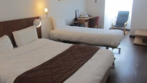 A hotel room with two beds, a desk, a chair, and a small table. - Hôtel Le Saint-Joseph (Saint-Éloy-les-Mines)