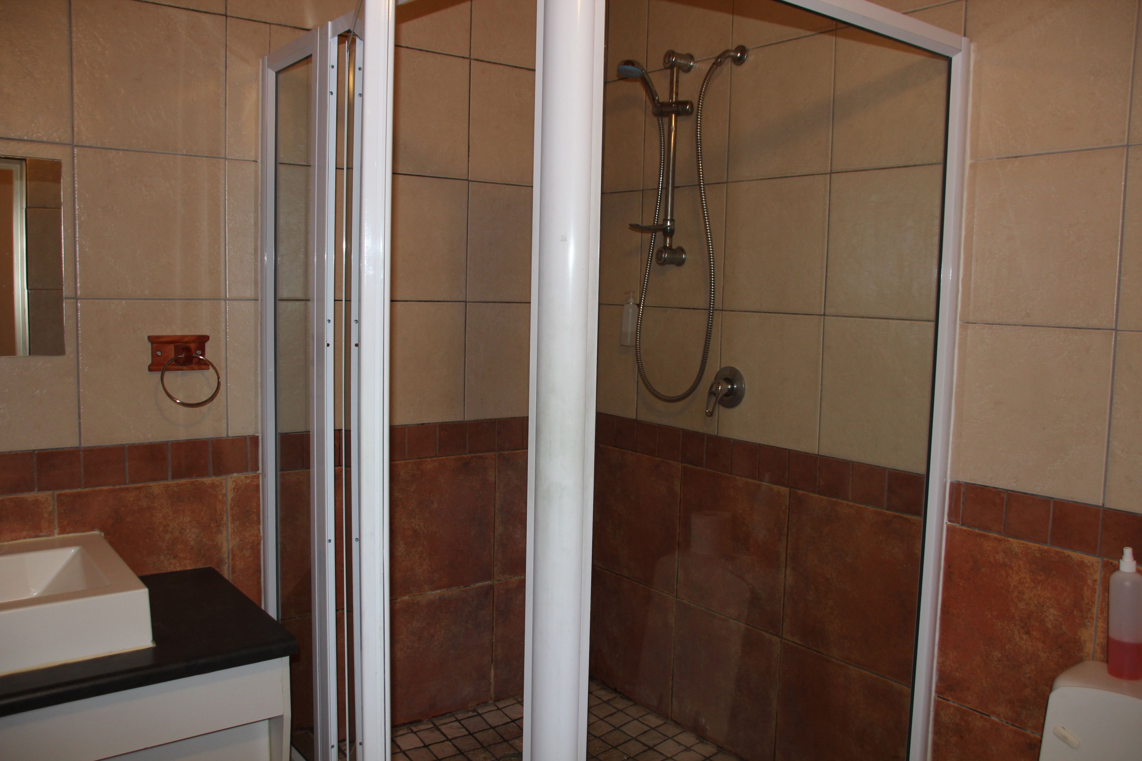 Ein Badezimmer mit Dusche, Waschbecken und Toilette.