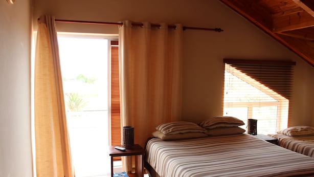 Un dormitorio con una cama, una mesita de noche y una ventana con persianas.