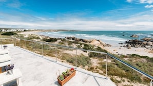 Ein Balkon mit Blick auf den Strand und das Meer.