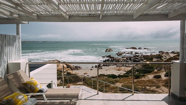 Ein Balkon mit Blick auf das Meer, ausgestattet mit Geländer und einigen Liegestühlen.