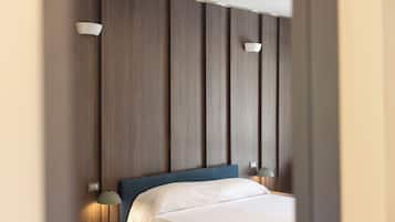 Habitación de hotel con una cama grande, dos lámparas de noche y un panel de pared de madera.