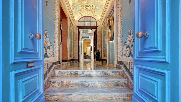 A grand hallway with marble steps leading to a room with a large mirror and a statue. - Palazzo Paolina Boutique Hotel (Valletta)