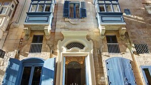 A multi-story building with a central entrance, balconies, and a stone facade. - Palazzo Paolina Boutique Hotel (Valletta)