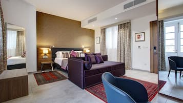 Una habitación de hotel moderna con una cama grande, un sofá, una silla y un escritorio.