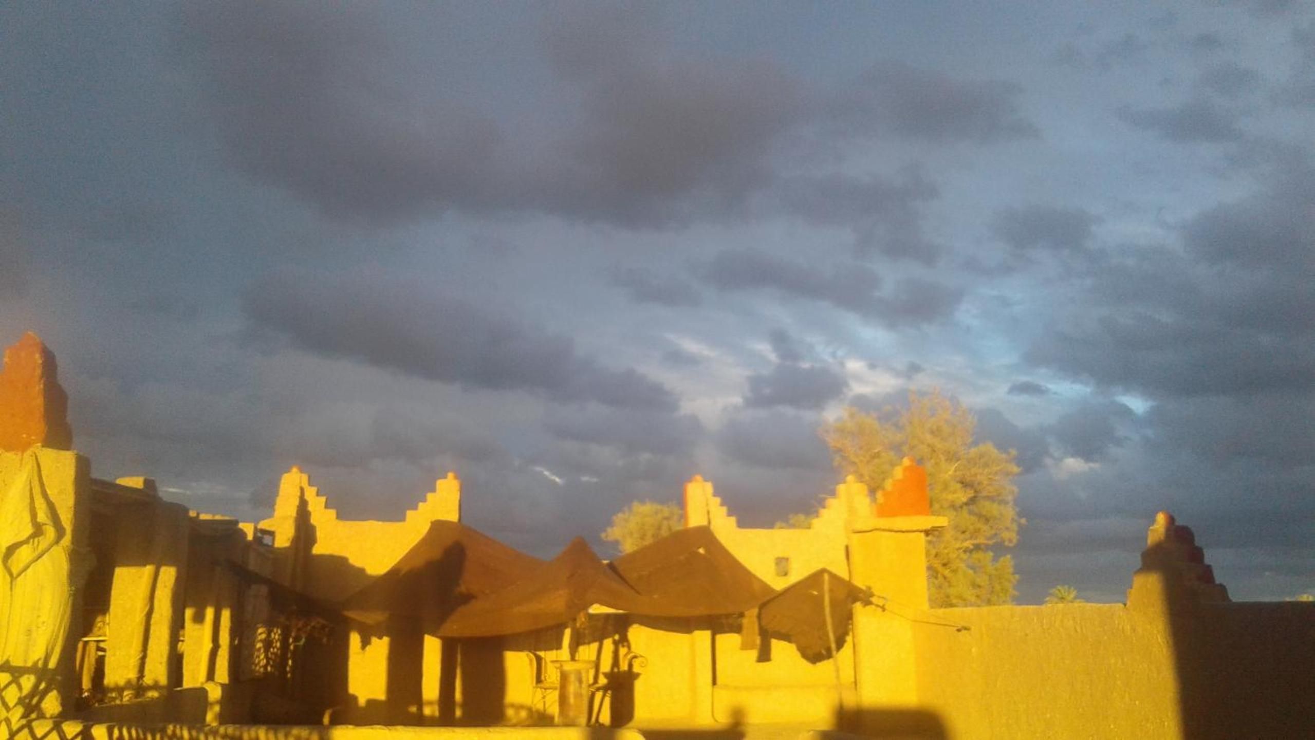 A traditional building with multiple structures, including a prominent tower and several smaller buildings with flat roofs.