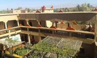 Un edificio de varios pisos con un patio, que presenta un techo de paja y arquitectura tradicional.