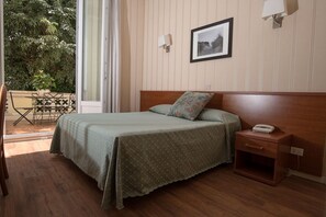 Une chambre à coucher avec un lit, une table de chevet et une fenêtre.