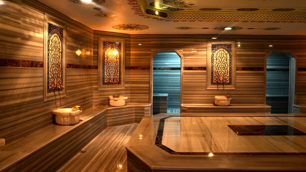 A luxurious bathroom with marble walls, ornate stained glass windows, and a central marble sink. - Cinarpark Hotel (Korfez)