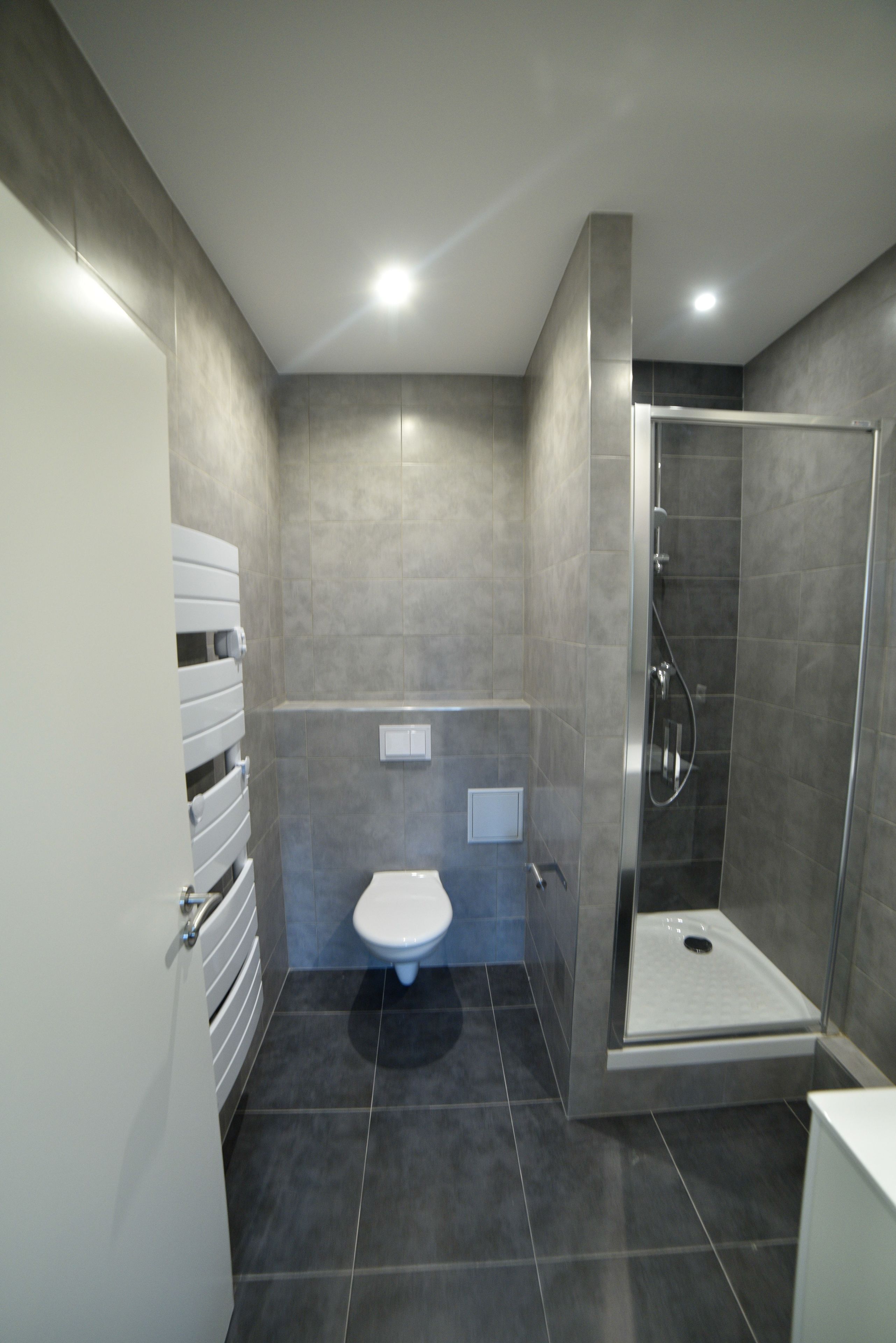Une salle de bain moderne avec des toilettes, une douche et un meuble blanc.