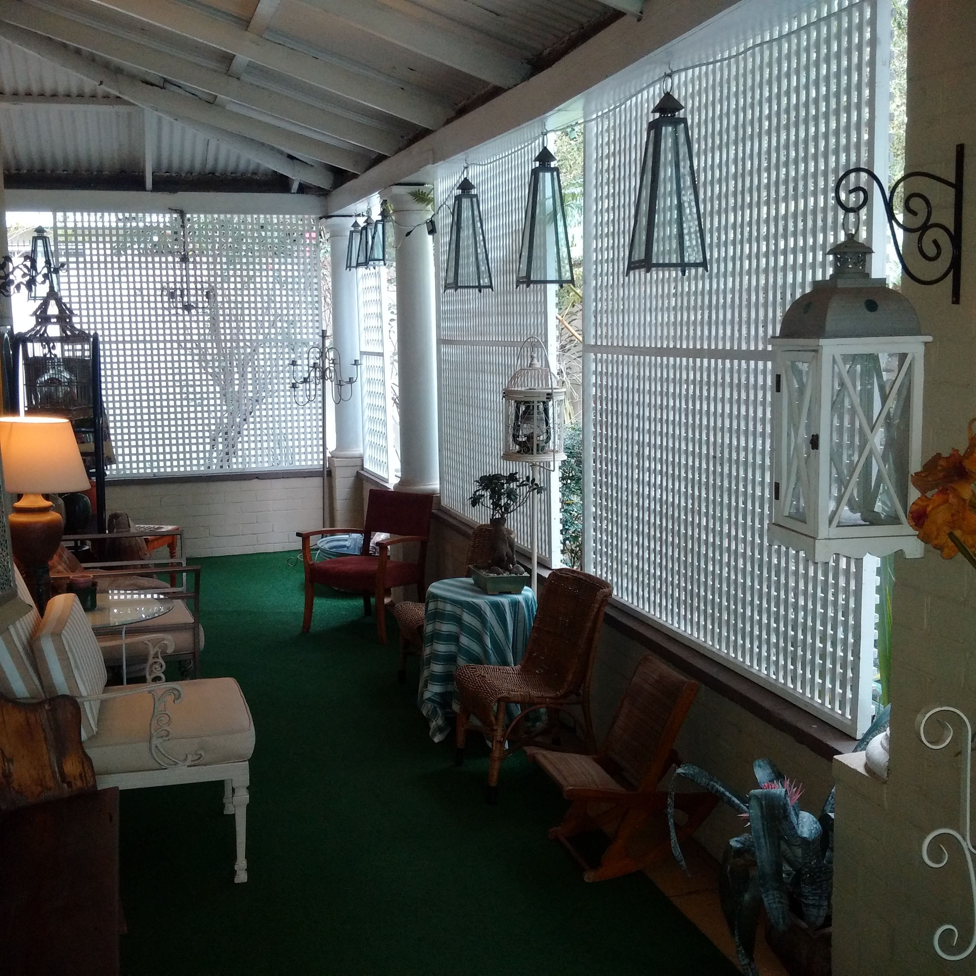 A cozy indoor seating area with wicker chairs, a small table, and a bench.