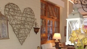 A cozy seating area with a wooden bench, a cushioned chair, and a small table with a lamp. - 79 On Ridge BNB (Pietermaritzburg)