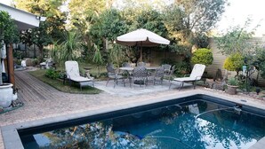 A backyard with a swimming pool, patio furniture, and a covered seating area. - 79 On Ridge BNB (Pietermaritzburg)