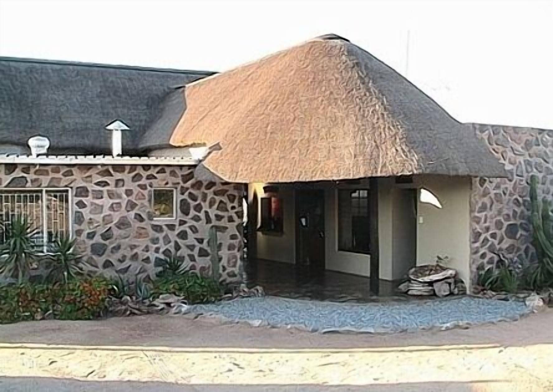 A stone building with a thatched roof, a small window, and a door.