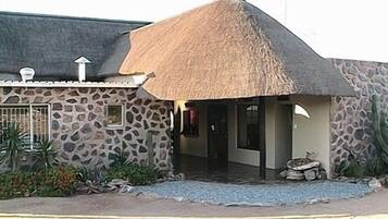 A stone building with a thatched roof, a small window, and a door.