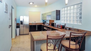 Una cocina compacta equipada con refrigerador, microondas y cafetera.