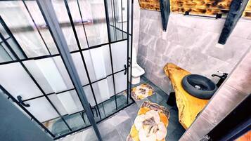 A small bathroom with a toilet, a sink, and a shower area.