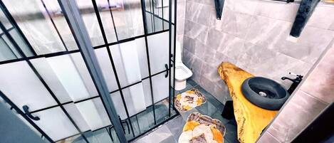 Un baño pequeño con inodoro, lavamanos y zona de ducha.