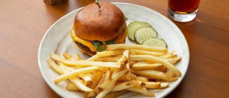 A plate with a burger and fries on a wooden table.