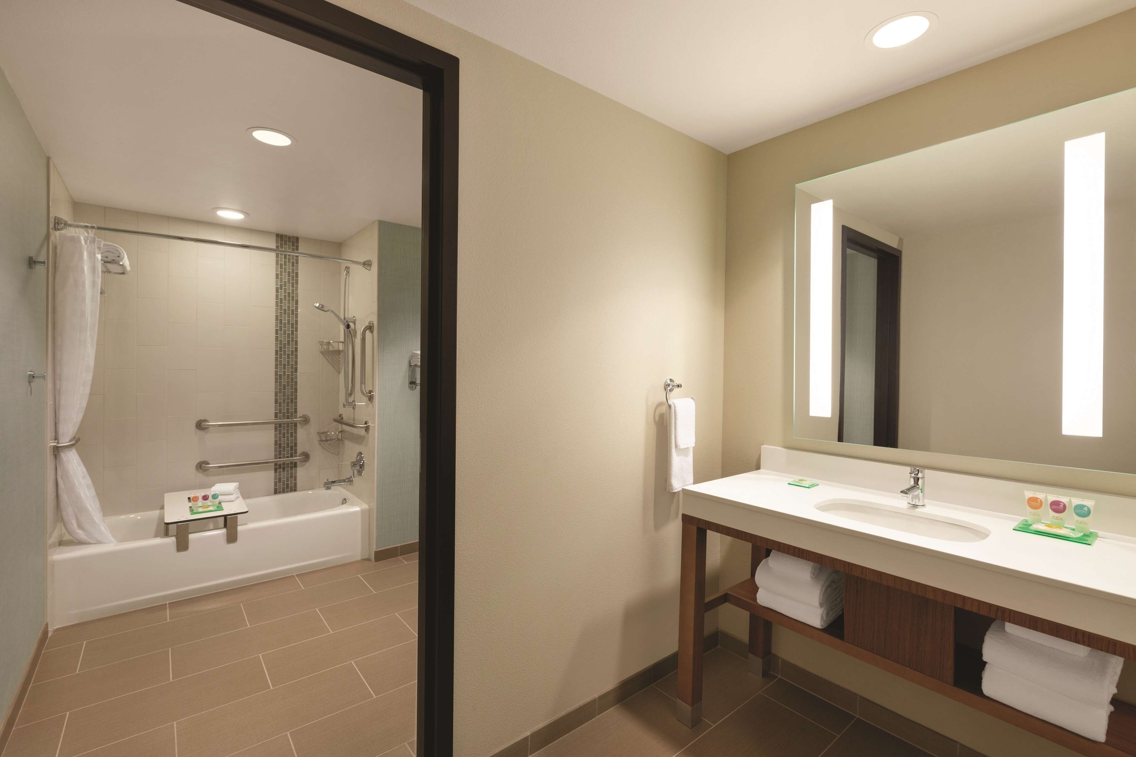 A bathroom with a bathtub, a sink, and a mirror.