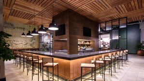Un espace bar avec un plafond en bois, des tabourets de bar et un comptoir.