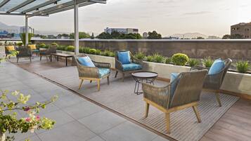 Una piscina al aire libre, sombrillas, sillones reclinables de piscina
