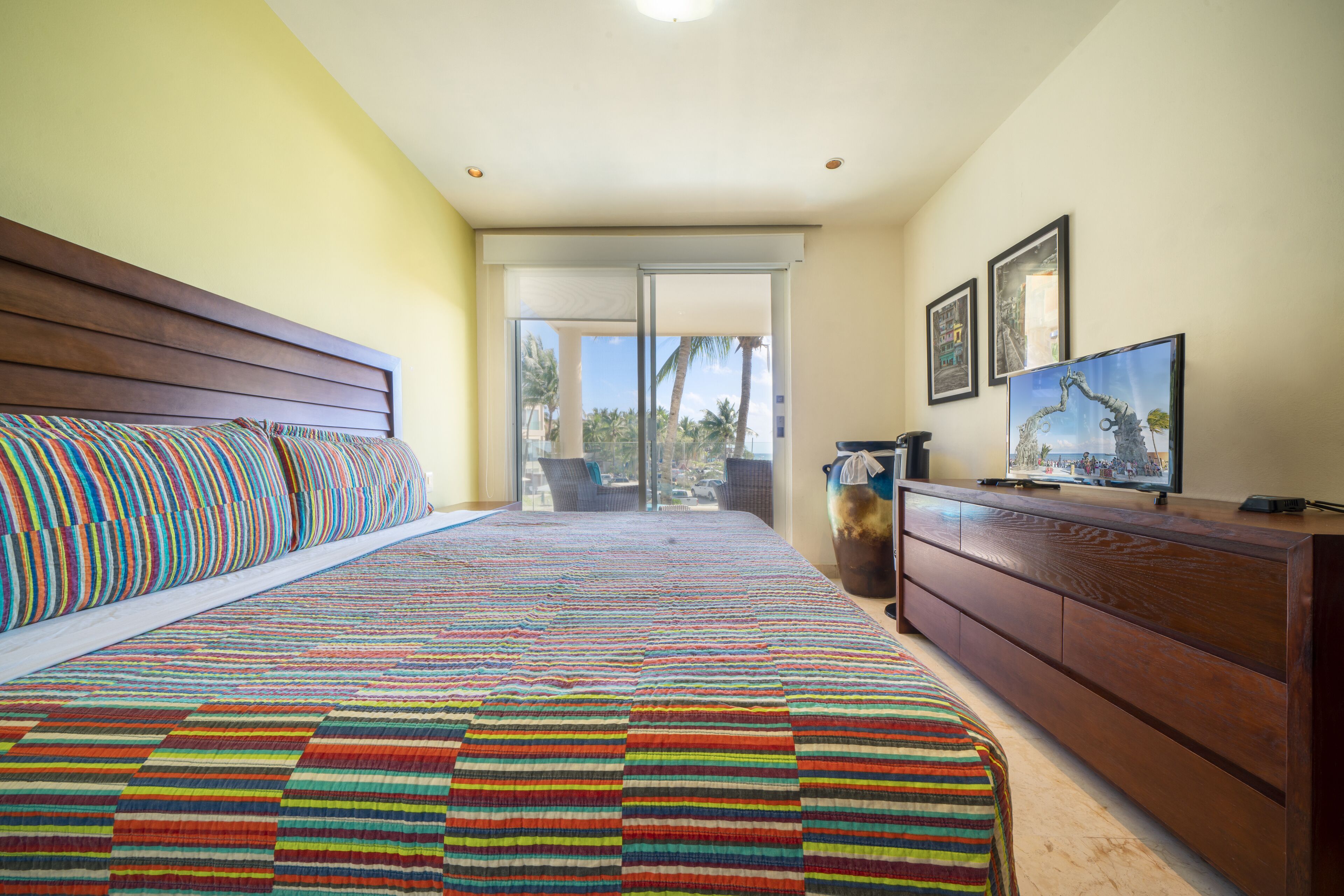Un dormitorio con una cama grande, un aparador de madera y un televisor.