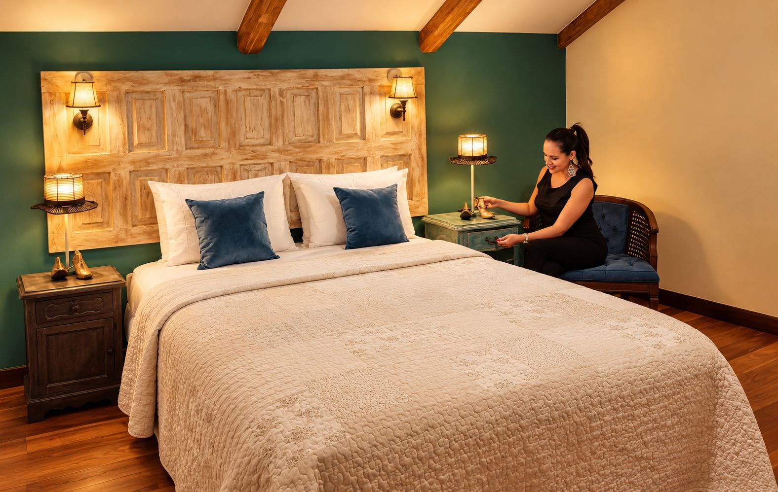A bedroom with a large bed, two bedside lamps, a nightstand, and a chair.