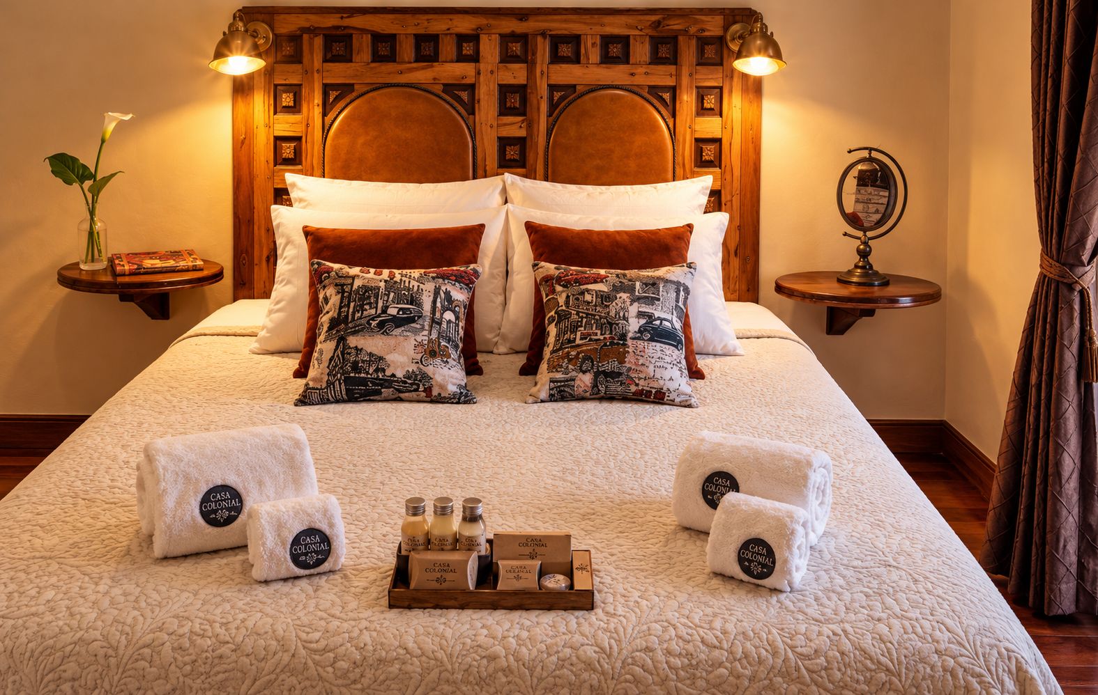 A hotel room with a large bed, two nightstands, a wooden headboard, and a bedside table with a lamp.
