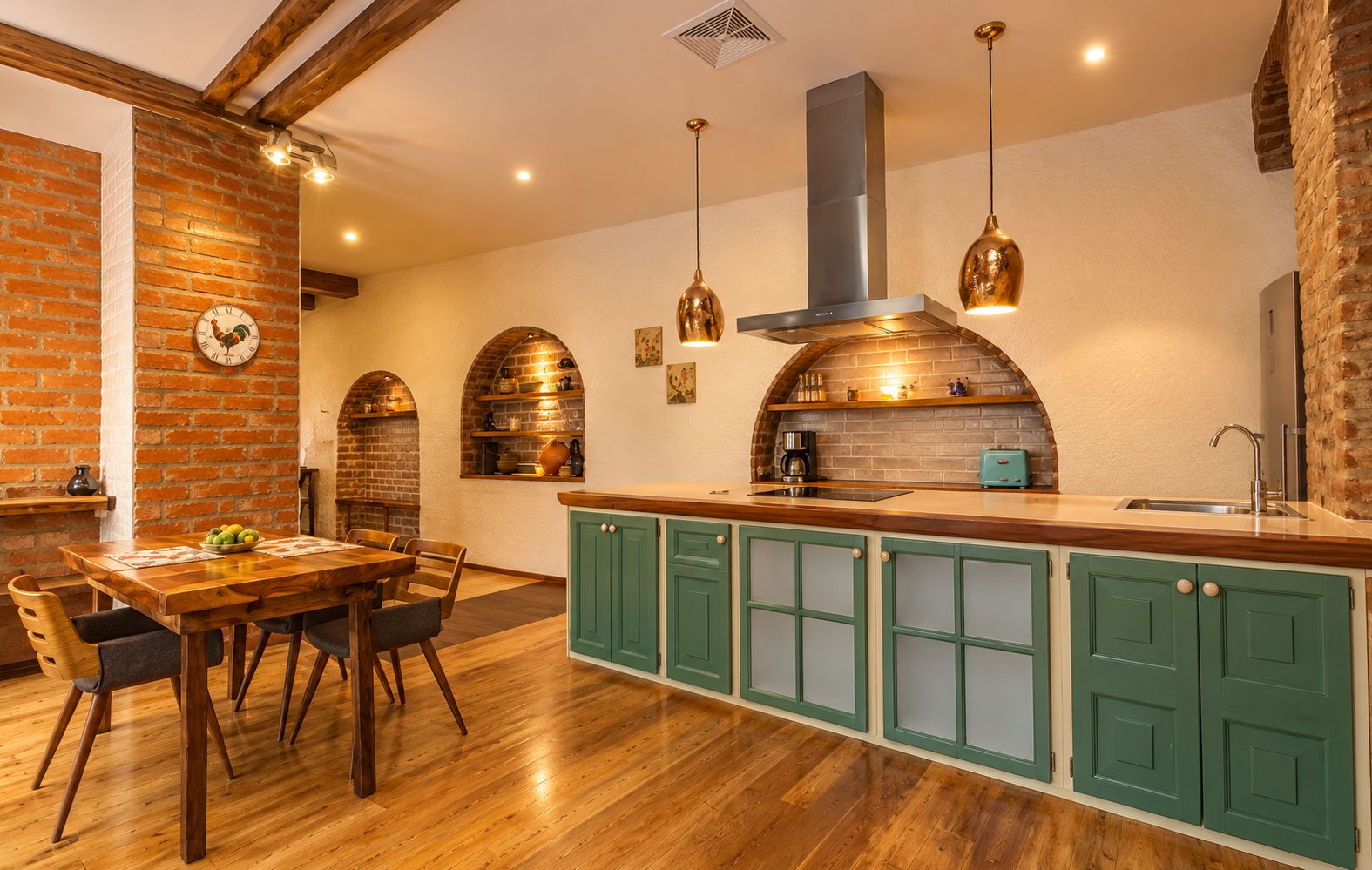 A kitchen with a wooden island, green cabinets, and a brick wall.
