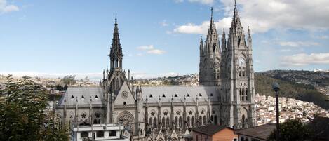 Una gran catedral con intrincada arquitectura gótica, que presenta múltiples agujas y una destacada torre del reloj.