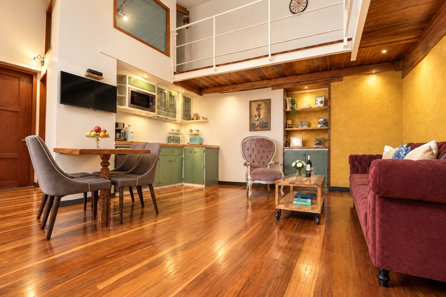 Un vaste espace de vie doté d’un plancher en bois, d’une table à manger avec des chaises, d’un canapé et d’un téléviseur fixé au mur.