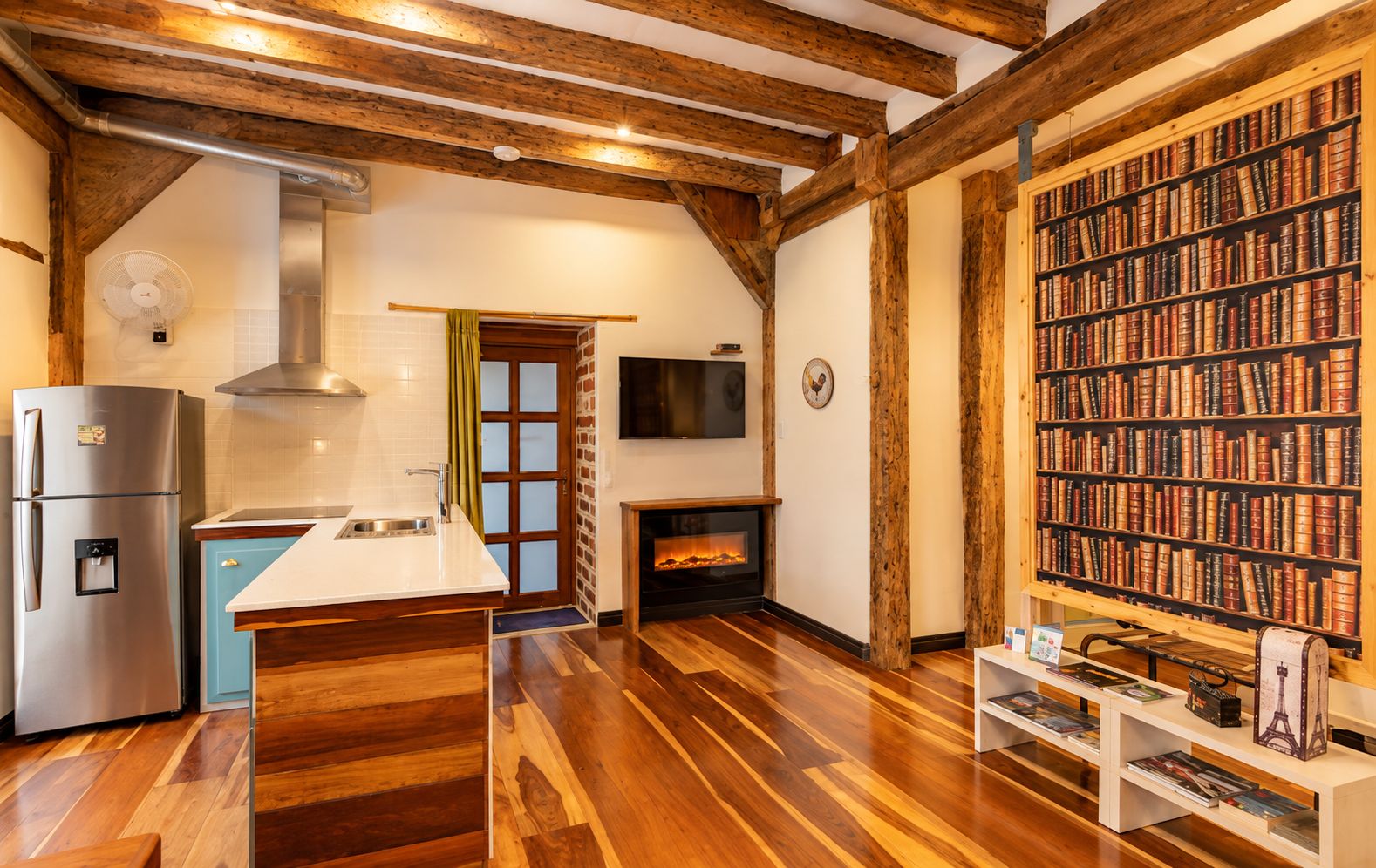 Una cocina moderna con refrigerador integrado, una isla central y una chimenea.