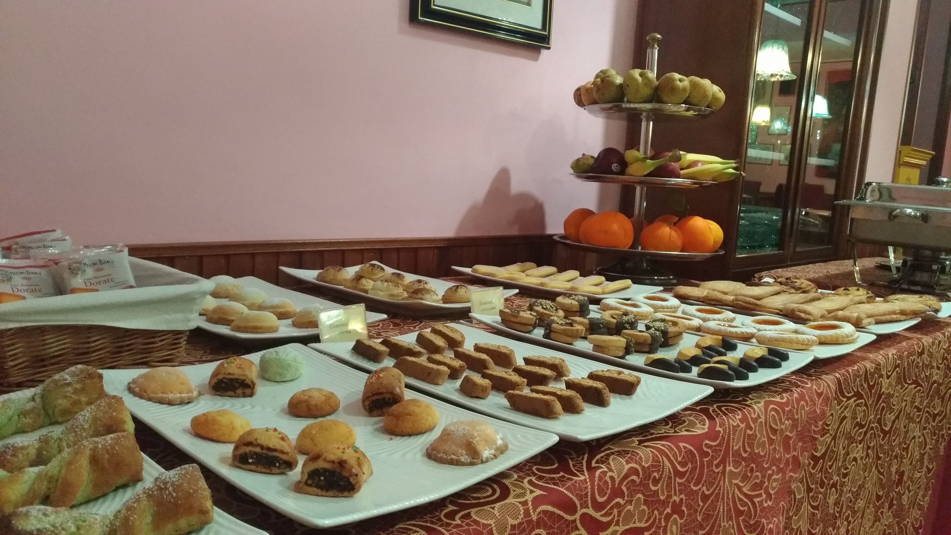 A buffet with various pastries, fruits, and desserts.