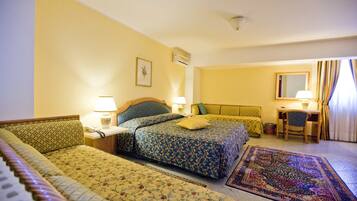 A hotel room with two beds, a desk, a chair, and a large rug.